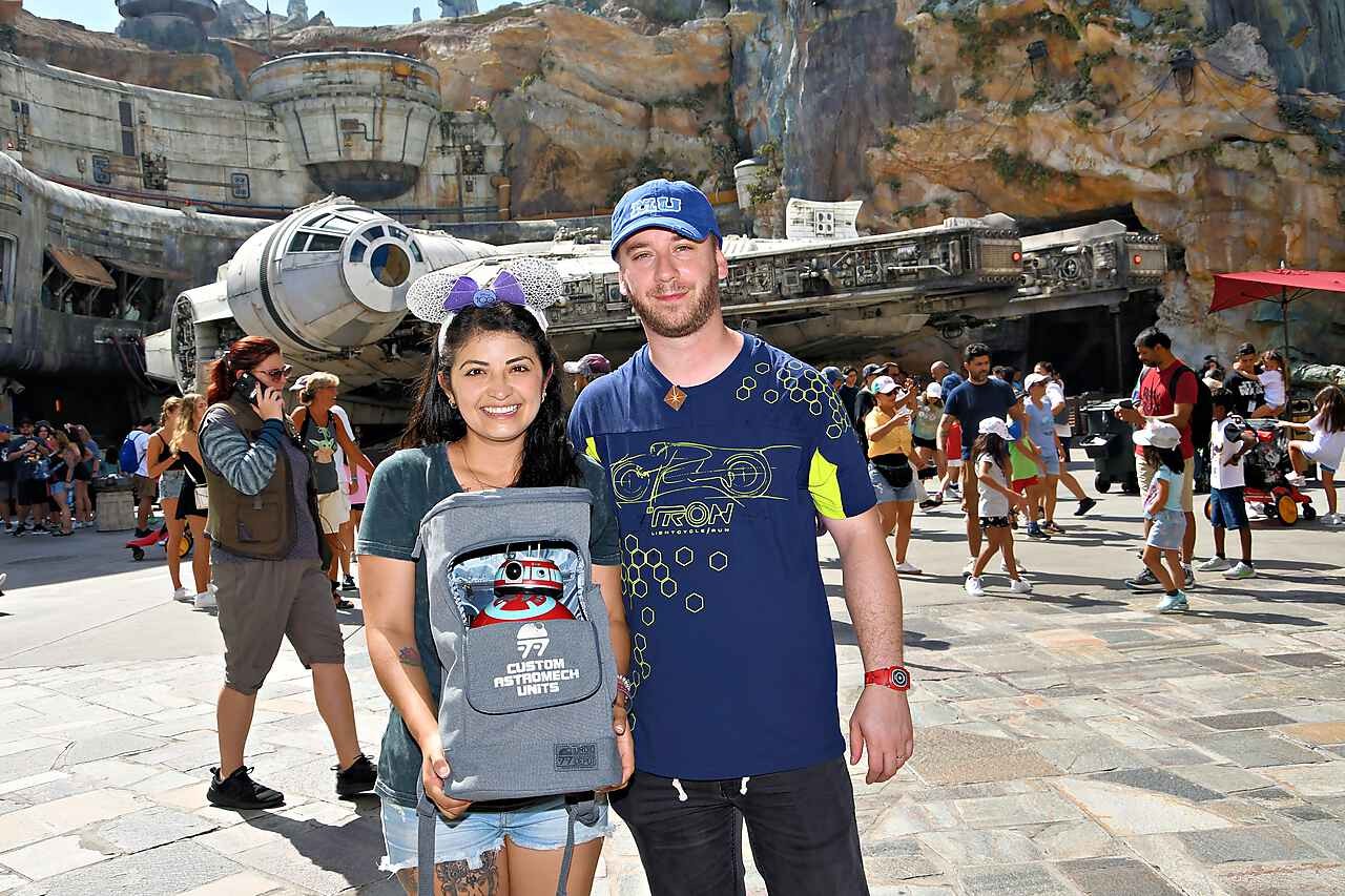 Pareja visitando Star Wars: Galaxy's Edge en un parque Disney